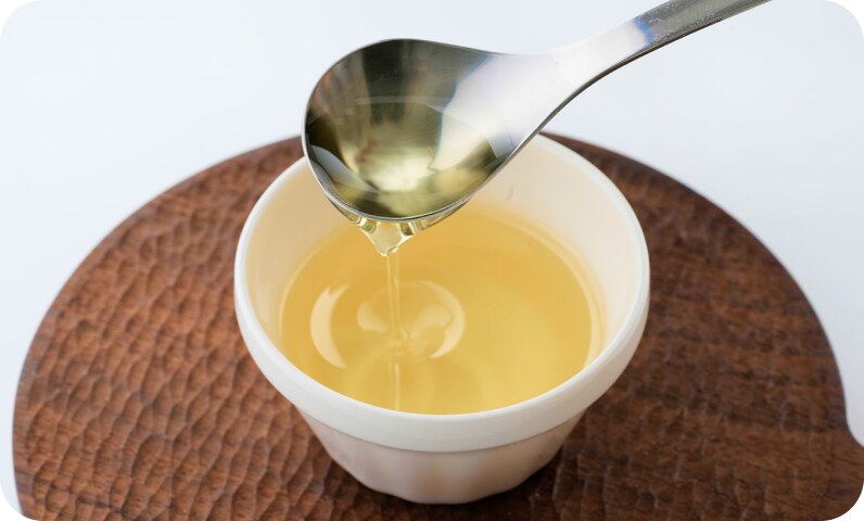スプーンからフライパンに油を注ぐ
