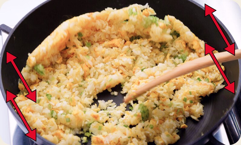 フライパンを前後に揺らしながらチャーハンを炒めているところ