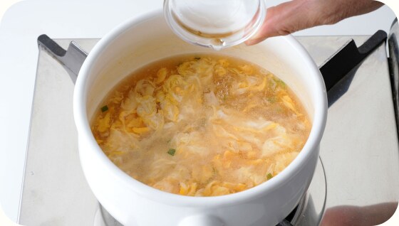 鍋のスープに水溶き片栗粉を加えているところ