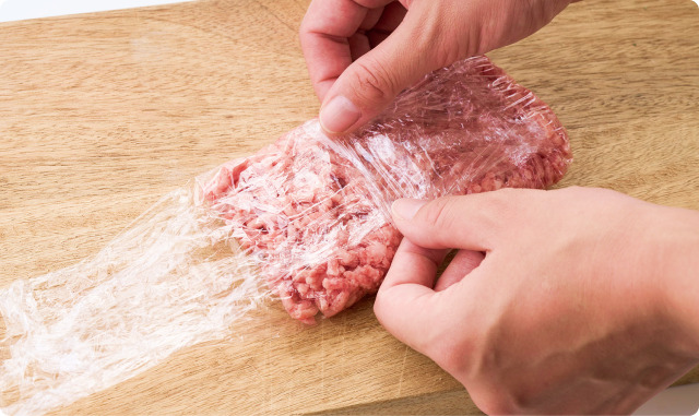 まな板の上でひき肉をラップで包んでいるところ