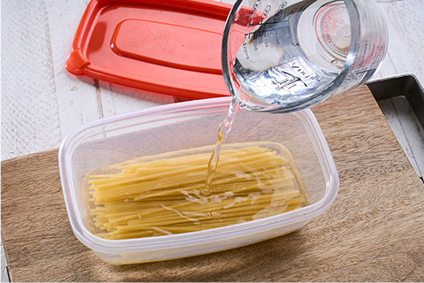 タッパーにパスタを入れる