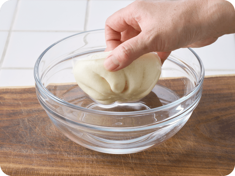 肉まんを水にくぐらせる