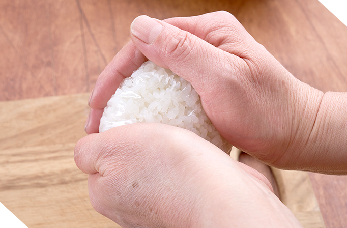 温かいご飯をやさしくラップで握る