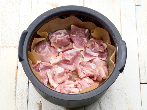 円形にカットしたクッキングシートを敷き、カットした鶏肉、だいこんの順にのせます。